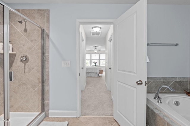 ensuite bathroom featuring a stall shower, a garden tub, tile patterned flooring, and baseboards