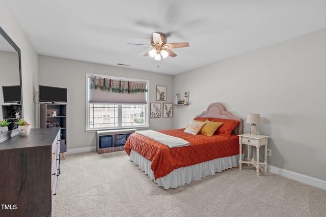 bedroom featuring light colored carpet, baseboards, and ceiling fan