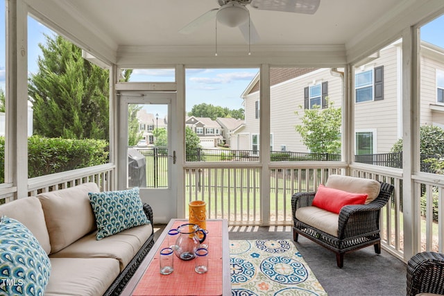 sunroom with a ceiling fan, outdoor lounge area, and a residential view