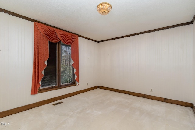 spare room featuring carpet floors, visible vents, and baseboards