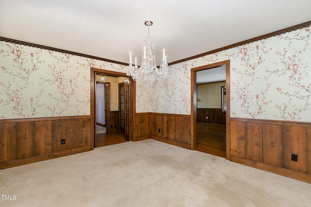 empty room with wainscoting and wallpapered walls