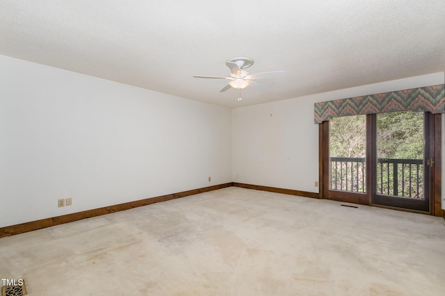 carpeted empty room featuring visible vents, ceiling fan, a textured ceiling, and baseboards