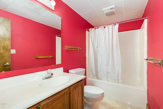 full bathroom with a drop ceiling, vanity, toilet, and shower / bath combo with shower curtain