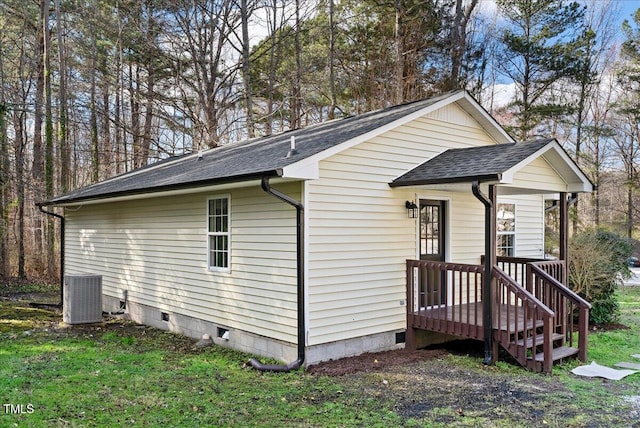 view of side of home featuring a shingled roof, cooling unit, crawl space, and a yard