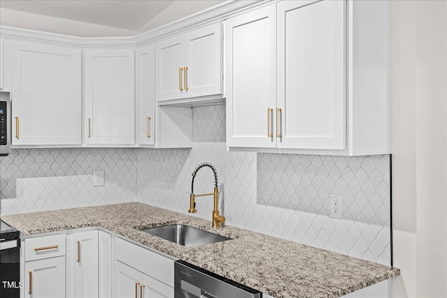 kitchen with a sink, white cabinetry, decorative backsplash, dishwasher, and stainless steel microwave