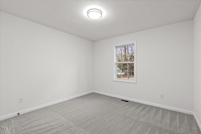 carpeted spare room featuring baseboards and visible vents