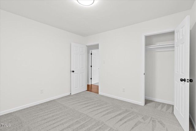 unfurnished bedroom featuring a closet, carpet, and baseboards