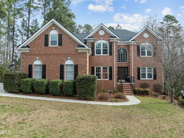 view of front of house featuring a front yard and brick siding