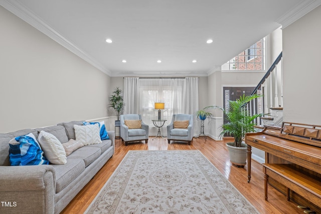 living area with light wood-style flooring and ornamental molding