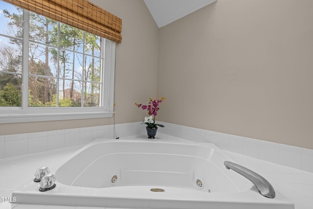 full bath featuring a whirlpool tub and vaulted ceiling