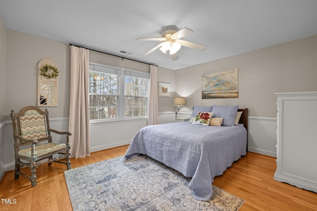 bedroom featuring visible vents, baseboards, ceiling fan, and light wood finished floors