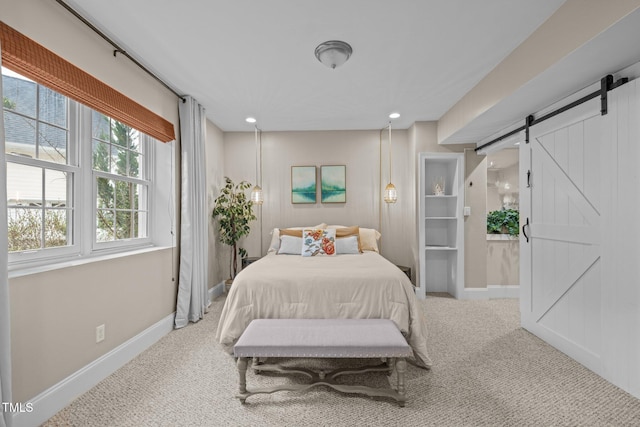 bedroom with a barn door, recessed lighting, carpet, and baseboards