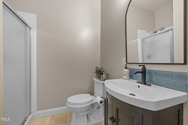 bathroom with baseboards, toilet, a stall shower, tile patterned floors, and vanity