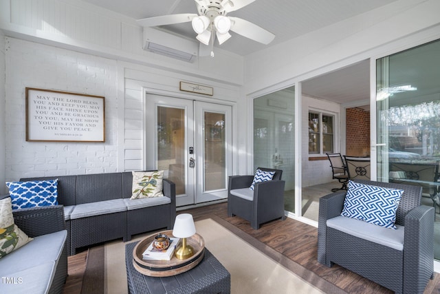 living area with french doors, brick wall, ceiling fan, and wood finished floors