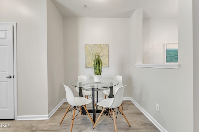 dining area featuring wood finished floors and baseboards