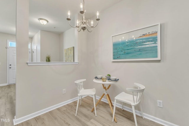 dining area with a notable chandelier, baseboards, and wood finished floors