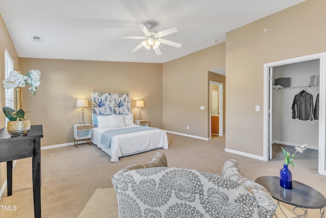 carpeted bedroom featuring baseboards, visible vents, a ceiling fan, lofted ceiling, and a walk in closet