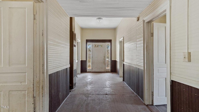 corridor featuring wood-type flooring and wooden walls