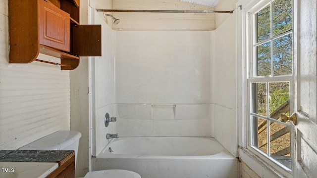 bathroom featuring washtub / shower combination and toilet