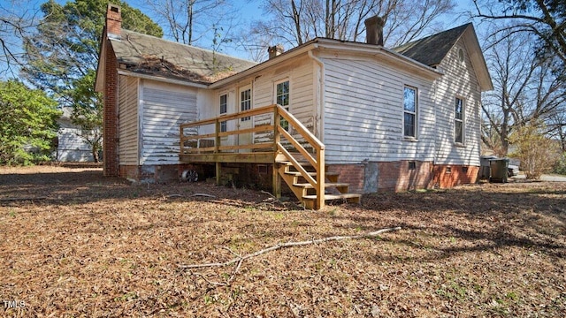 back of house with stairs, a chimney, and a wooden deck