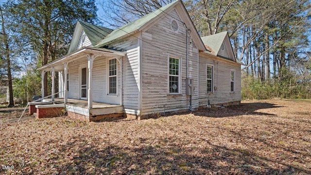 view of home's exterior with covered porch and a shingled roof