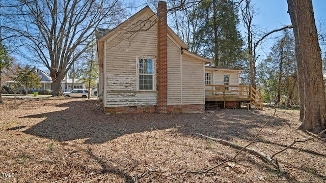 back of house featuring crawl space, a chimney, stairway, and a wooden deck