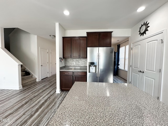 kitchen with tasteful backsplash, dark brown cabinetry, wood finished floors, stainless steel fridge, and baseboards