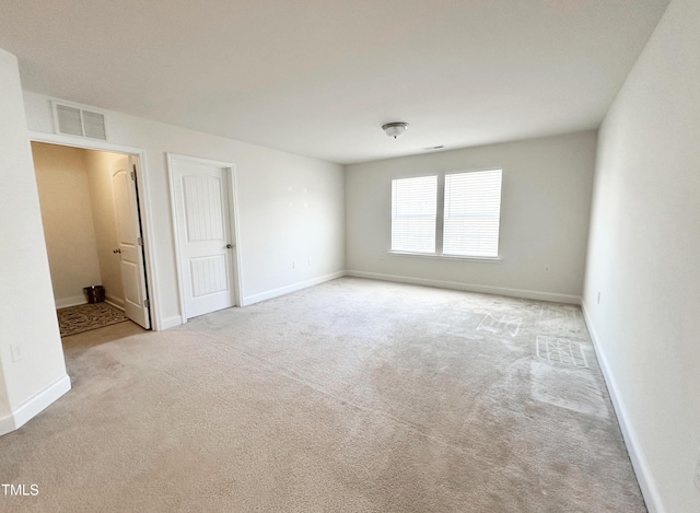 carpeted empty room featuring visible vents and baseboards