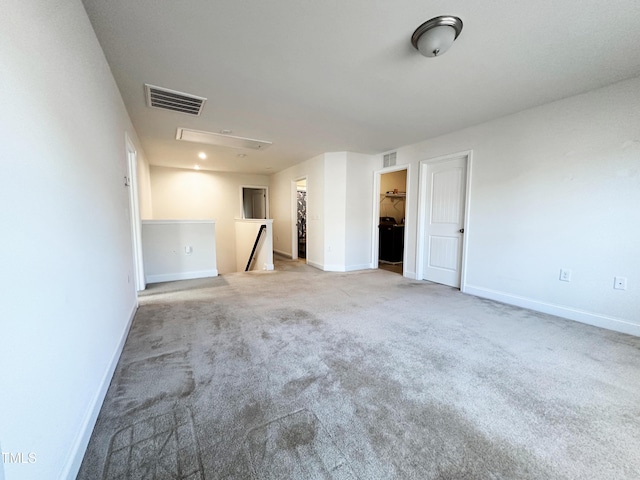 carpeted empty room with visible vents and baseboards