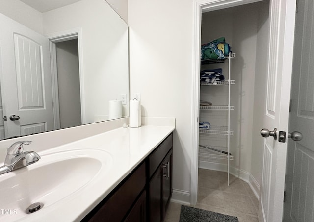 bathroom with tile patterned floors, baseboards, and vanity