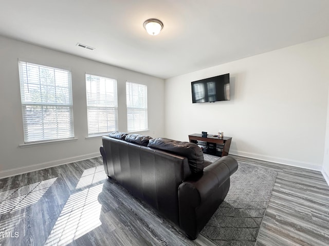 living room with dark wood-style floors, baseboards, and visible vents