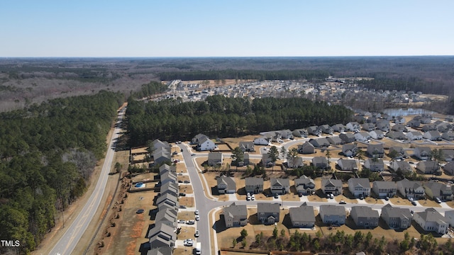 drone / aerial view with a water view, a residential view, and a view of trees