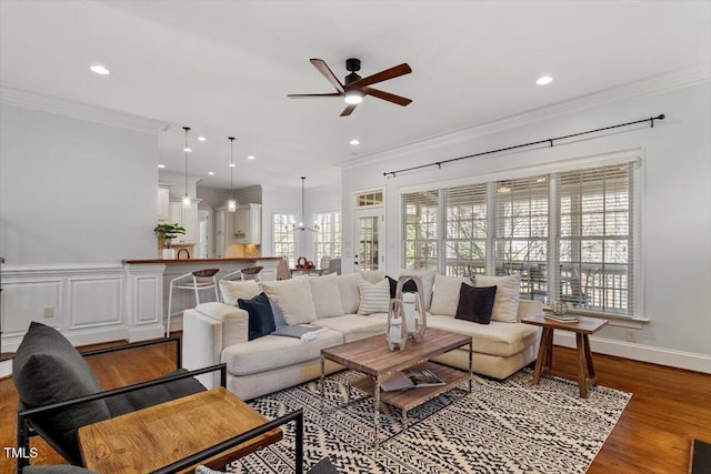 living room with recessed lighting, crown molding, and wood finished floors