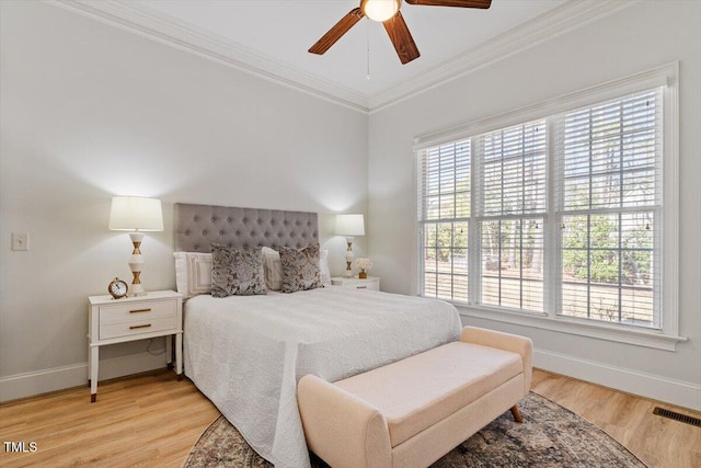 bedroom with baseboards, multiple windows, wood finished floors, and crown molding