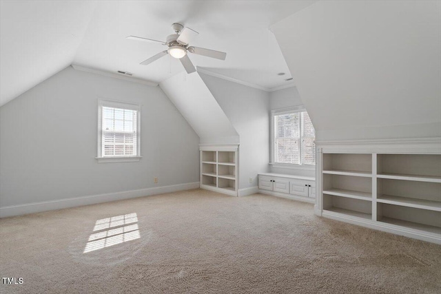 additional living space featuring a healthy amount of sunlight, baseboards, light carpet, and visible vents