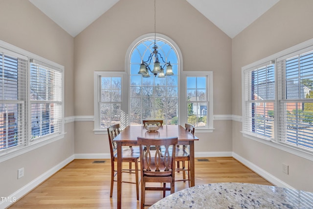 dining area with visible vents, baseboards, lofted ceiling, an inviting chandelier, and light wood-type flooring