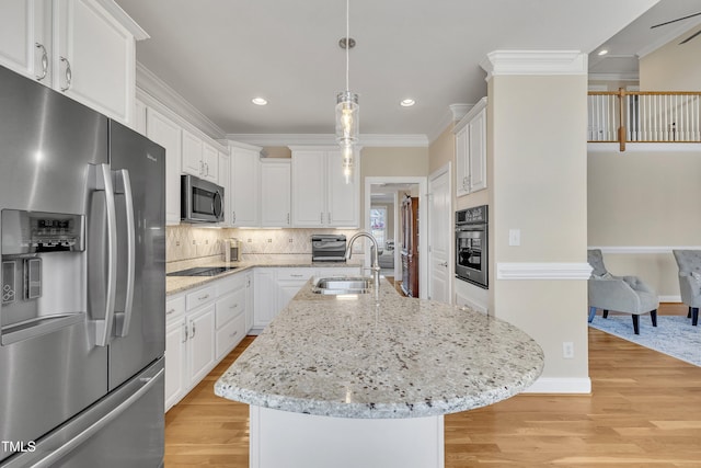 kitchen featuring white cabinets, stainless steel appliances, crown molding, light wood-type flooring, and a sink