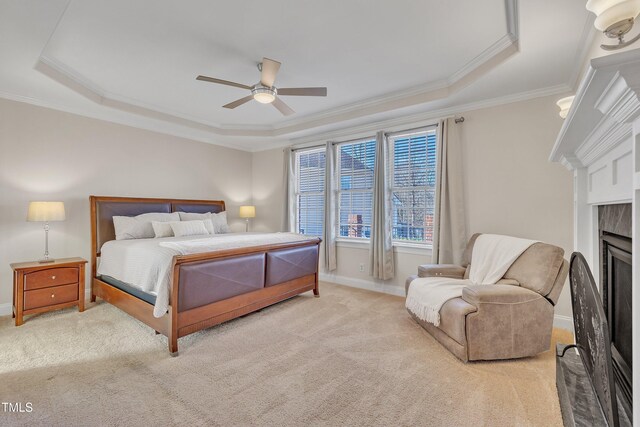 carpeted bedroom featuring ornamental molding, a raised ceiling, a fireplace, and baseboards