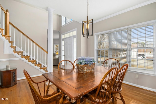 dining space with ornate columns, stairs, baseboards, and wood finished floors