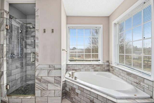 full bath featuring a shower stall, a textured ceiling, and a bath