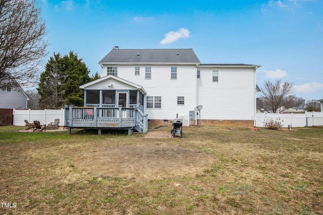 rear view of property featuring an outdoor fire pit, a lawn, a fenced backyard, and a sunroom