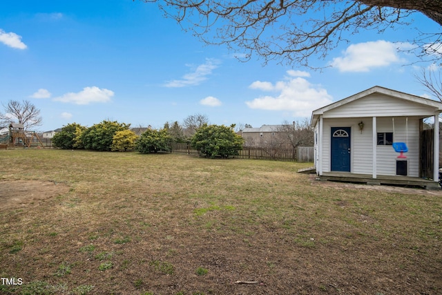 view of yard with a fenced backyard, a playground, and an outbuilding