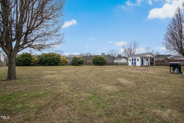 view of yard with fence and an outbuilding