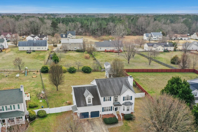 drone / aerial view with a wooded view and a residential view