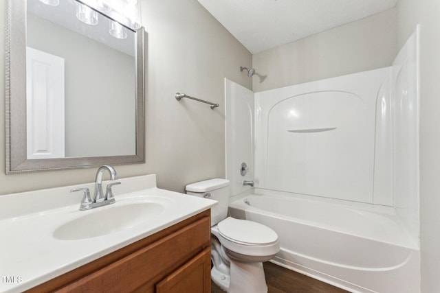 bathroom with toilet, shower / washtub combination, a textured ceiling, and vanity