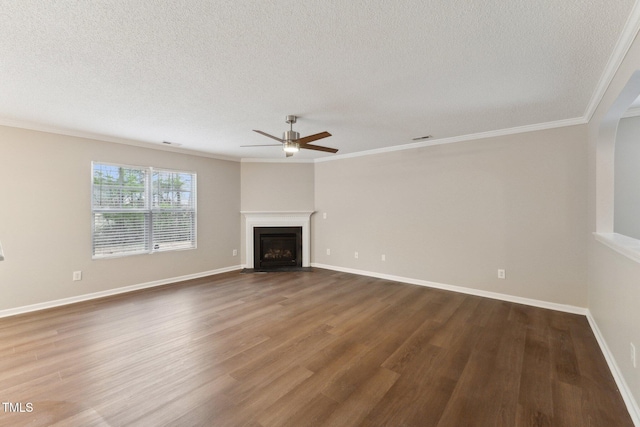 unfurnished living room with a fireplace with flush hearth, ornamental molding, baseboards, and wood finished floors