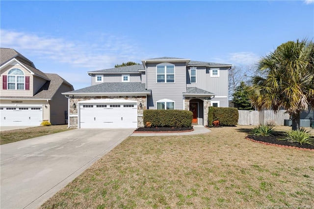 traditional-style home with fence, a garage, stone siding, driveway, and a front lawn