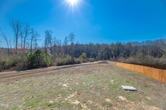 view of yard featuring fence and a view of trees