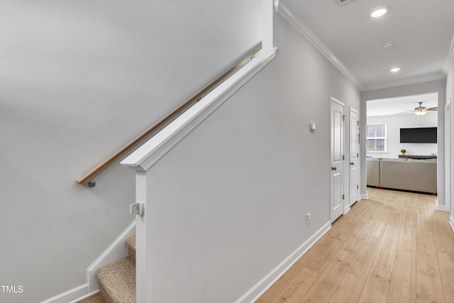 staircase featuring crown molding, recessed lighting, a ceiling fan, baseboards, and hardwood / wood-style flooring