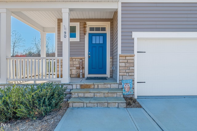 view of exterior entry featuring stone siding and a porch